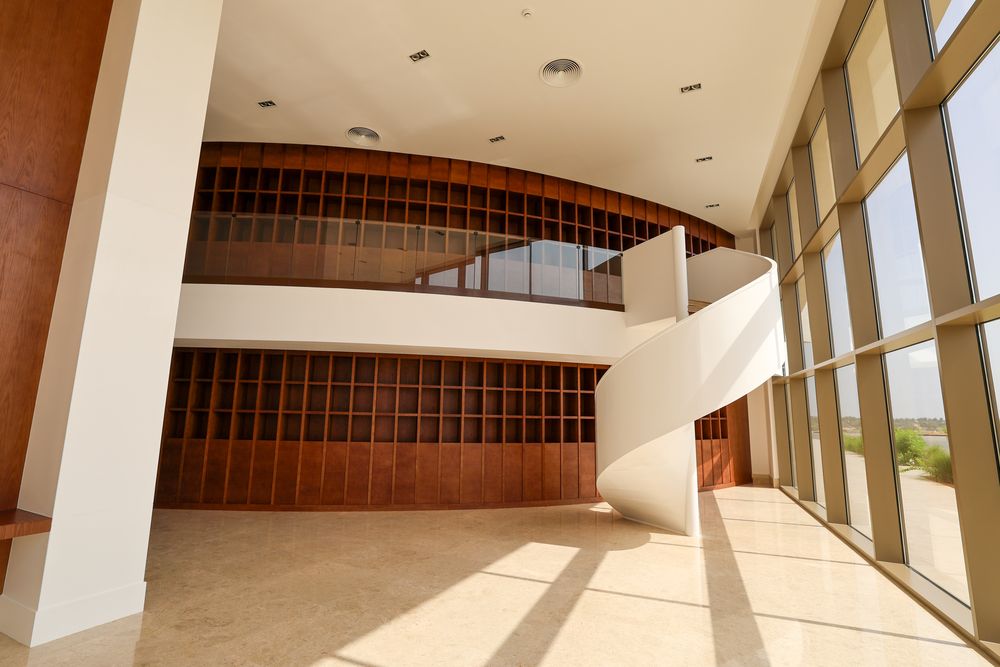 Double-height atrium — curved oak grid wall and spiral stair