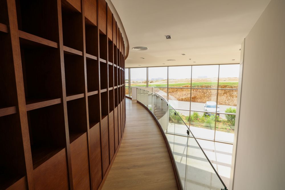 Curved oak library wall along the upper gallery